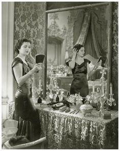 an old photo of two women in front of a mirror looking at their own reflection