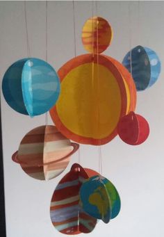 a mobile made out of paper with different colored balls hanging from it's sides