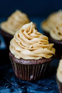 some cupcakes with frosting on them sitting on a table