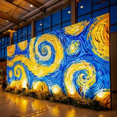 a large painting is displayed in front of a wall with lights and plants on it