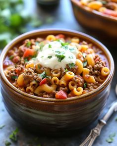 a bowl of chili macaroni and cheese with a spoon next to the bowl