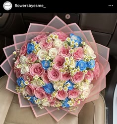 a bouquet of pink, blue and white flowers in the back seat of a car