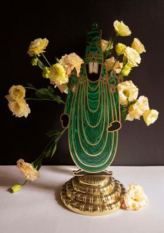 a vase filled with flowers sitting on top of a white table next to yellow roses