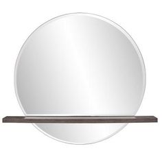 a round mirror sitting on top of a wooden shelf