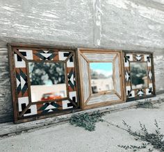 three mirrors mounted to the side of a building