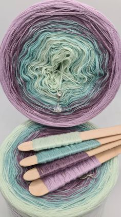 three skeins of yarn sitting next to each other on top of a container