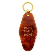 a keychain with the words home sweet home written in gold lettering on it