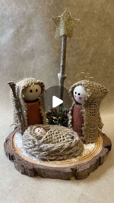 a nativity scene with two small dolls and a star on the top of it