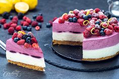 two slices of cheesecake with raspberries and blueberries on the top one slice is missing