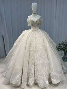 a white wedding dress on display in front of a curtain