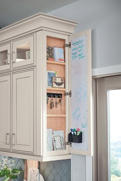 a kitchen cabinet with writing on the door