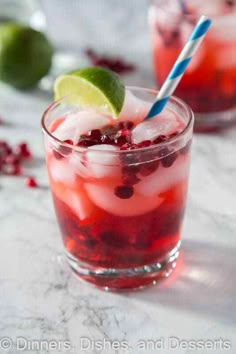 two glasses filled with cranberry lemonade and lime juice on a marble table