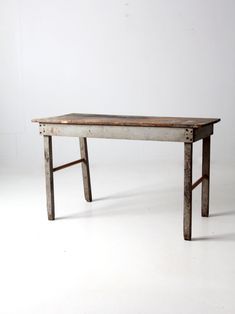 an old wooden table sitting on top of a white floor