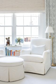 a living room with white furniture and curtains