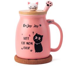 a pink coffee mug with a black cat on it