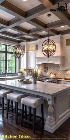 a large kitchen island with stools and lights hanging from it's ceiling above