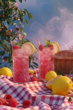 two pink lemonade cocktails with strawberries on a checkered tablecloth and flowers