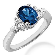 a blue and white diamond ring with three stones on the side, set in 18k white gold