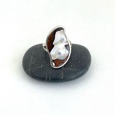 This is an unusual mother of pearl stone ring. The vintage sterling silver ring has a unique nacre stone. It has striking markings set in an unusual shaped crown. The ring has tested positive for sterling silver and is marked 925 inside the band. The womens or mens ring is a UK size O and US size 7 1/2. The crown is approx 1 1/8 inches (3cm) at its longest. The ring is in great vintage condition but has been left as found. It can be cleaned if requested. See ReTain ReUse for other gift ideas, be Gift Rings With Polished Mother Of Pearl Finish, Silver Mother Of Pearl Anniversary Ring, Oval Mother Of Pearl Ring With Polished Finish, Anniversary Silver Mother Of Pearl Rings, Silver Mother Of Pearl Ring As Gift, Silver Mother Of Pearl Ring For Gift, Silver Pearl Ring With Mother Of Pearl As Gift, Oval Mother Of Pearl Ring Gift, Oval Mother Of Pearl Ring For Gift