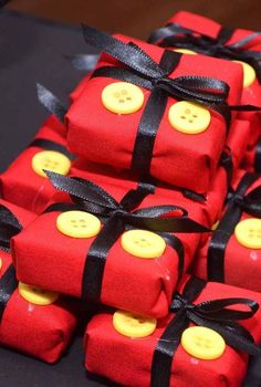 many red wrapped presents with yellow buttons and black ribbon