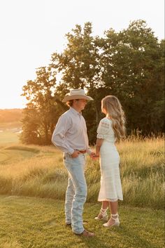 Engagement photo couple session cowboy hat engagement ring golf course wrangler jeans sunset white dress Engagment Picture Outfits Summer, White Dress Engagement Pics, Courtship Pictures, Cowgirl Engagement Pictures, Classy Country Engagement Photos, Country Chic Engagement Photos, Sundress Couple Pictures, Spring Engagement Photos Outfits Country