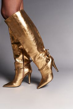 Luxury Gold Boots With Almond Toe, Luxury Gold Boots With Pointed Toe, Luxury Gold Glamorous Boots, Luxury Glamorous Metallic Boots, Luxury Gold Leather Boots, Luxury Gold Calf Leather Heels, Luxury Ankle Boots With Metal Details, Luxury Gold Heeled Boots, Luxury Metallic Boots With Round Toe