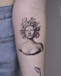 a woman's arm with a tattoo on it and a snake in her hair