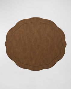 a round brown leather placemat on a white background