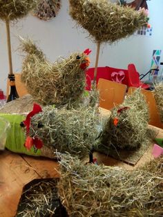 some hay is laying on the table and two chickens are sitting on top of it