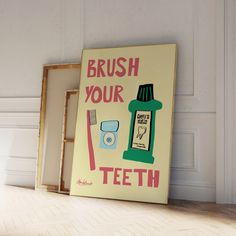 a brush your teeth sign on the floor next to a framed poster with toothpaste