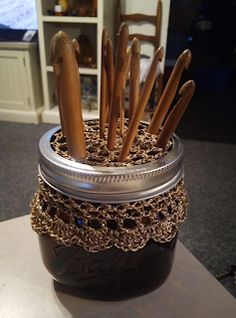 a jar filled with wooden spoons on top of a table