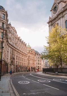 a city street with buildings and a clock tower in the background