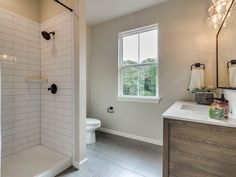 a bathroom with a sink, toilet and shower in it's own area that is well lit