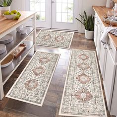 three rugs in the middle of a kitchen with wooden flooring and white cabinets