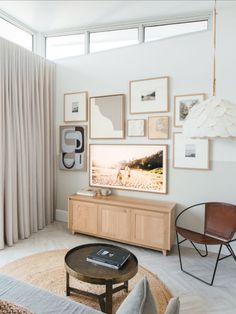 a living room filled with furniture and framed pictures on the wall above a flat screen tv