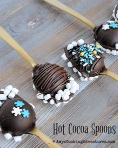 four chocolate covered spoons with marshmallows and sprinkles on them