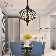 a dining room table with blue chairs and a chandelier hanging from the ceiling