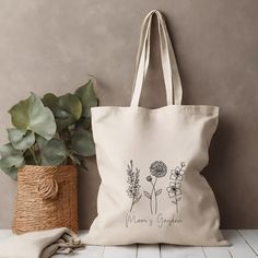 a tote bag sitting next to a potted plant