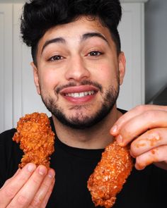 a man holding up two pieces of fried food