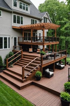 a wooden deck with steps leading up to the upper level and an attached pergolan