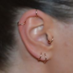 a close up of a person's ear with two small gold rings on it