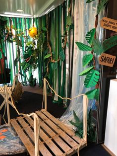 a bed made out of wooden pallets in a room with green curtains and plants