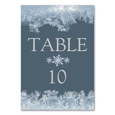 a table number card with snowflakes on the front and bottom, in grey