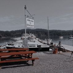 there is a sign that says welcome to the harbor and boats are docked in the water