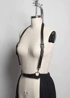 Mysterious, witchy harness belt skirt made in leather, PVC, or vegan leather. A floor-length gauze skirt with raw-edge ruffle is attached to a belt. Halter-style harness straps are detachable. This is a perfect layering piece. Fit is adjustable with buckles and straps at waist and shoulders.Silver-toned nickel plated steel hardware. Shown in black vegan leather. Skirt is designed to graze the floor and is 40" long . If you would like the length adjusted for your height, please let us know in the Harness Skirt, Gothic Harness, Goth Skirt, Gauze Skirt, Harness Belt, Festival Attire, Belt Skirt, Gauze Skirts, Witchy Fashion