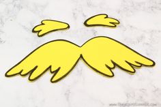 a yellow sticker with two wings on top of a marble countertop in the shape of an angel