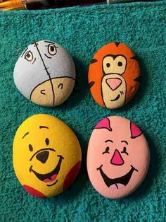 four painted rocks with faces on them