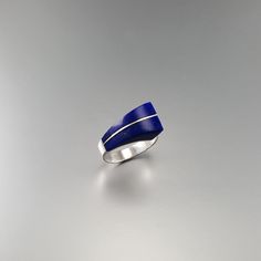 "Modern Lapis Lazuli and Sterling silver statement ring. Unique gift for her, wife, friend, girlfriend, September and December birthstone, 9 year anniversary. This stunning ring is a masterpiece of design and a true eye catcher and puts the center attention on the stone, which is only divided discreetly by a 0.5mm silver line. The natural gemstone shows all its beautiful faces with natural enclosures. This beautiful ring is worked with the technique of inlay, which means the stone is worked seam Modernist Gemstone Jewelry For Anniversary, Modernist Blue Gemstone Jewelry, Modern Silver Jewelry With Birthstone, Blue Sterling Silver Jewelry With Polished Finish, Modern Sterling Silver Promise Ring, Modern Sterling Silver Jewelry With Gemstones, Modernist Gemstone Jewelry For Gifts, Blue Minimalist Jewelry With Polished Finish, Formal Blue Lapis Lazuli Jewelry