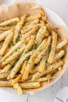 a white bowl filled with french fries on top of a table