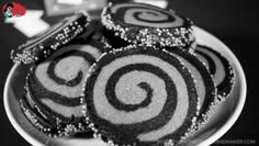 some black and white cookies on a plate with silver sprinkles in the middle